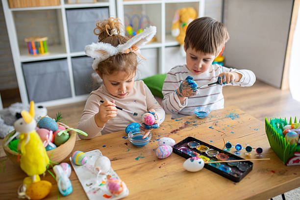istock Two little kids painting eggs for Easter holiday 2208961000
