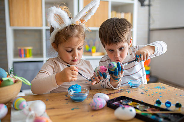 istock Two little kids painting eggs for Easter holiday 2208961457