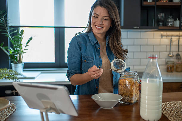 istock Young woman enjoying breakfast and video chat in modern kitchen 2208963343