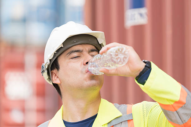 istock Drinking water,  worker and container cargo site. Male container yard worker break and drinking water at container cargo yard 2208966609