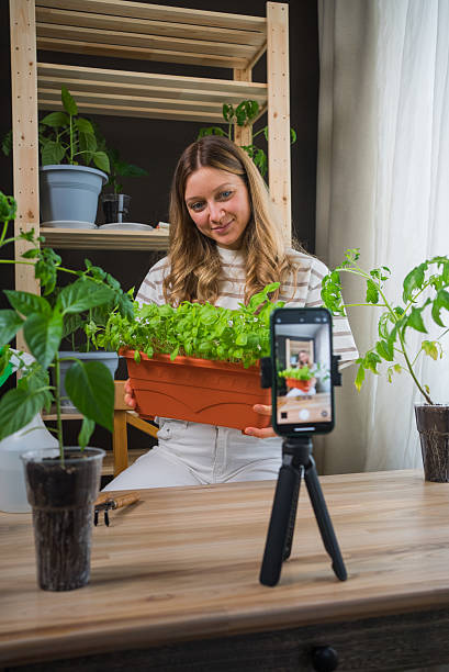 istock Woman Filming Indoor Gardening Tutorial with Potted Herbs 2208970521