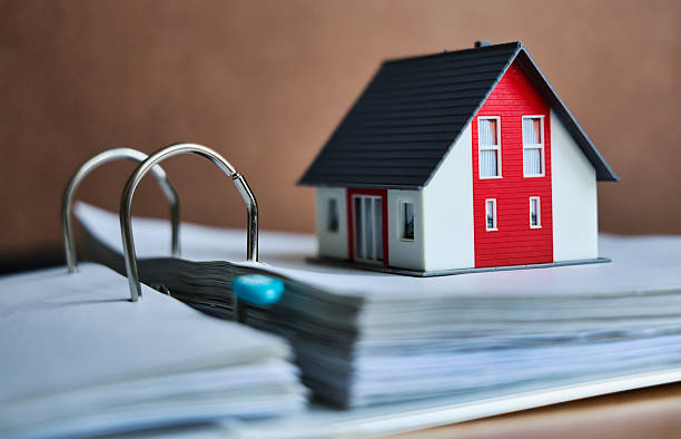 Miniature house on a file folder - concept for house purchase, management or construction financing