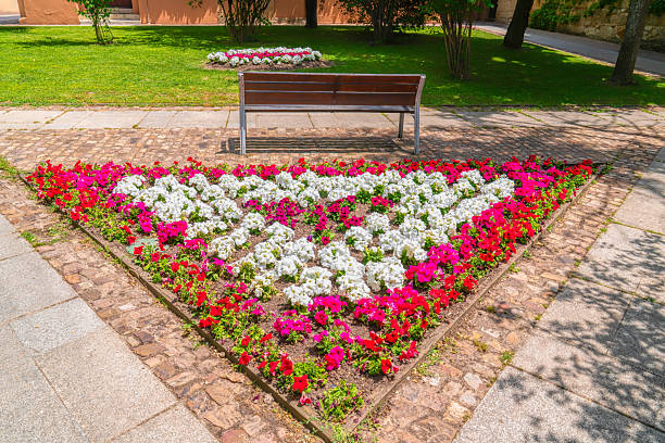 Triangular flower garden of red, white and pink flowers in a park