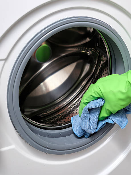 istock A woman's hand in a protective rubber glove wipes away moisture a washing machine. 2208976079