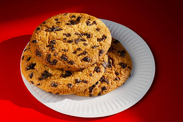 Homemade cookies with chocolate chips on a bright red background. Symbolizes culinary traditions and homemade baking.