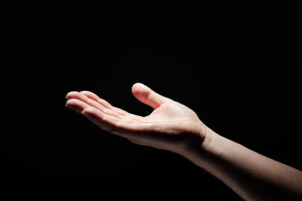 istock Man holds open palm of hand up towards light. 2208976384
