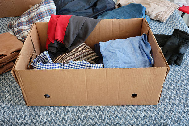 istock Cardboard donation box with things. Winter and summer clothes. 2208976491