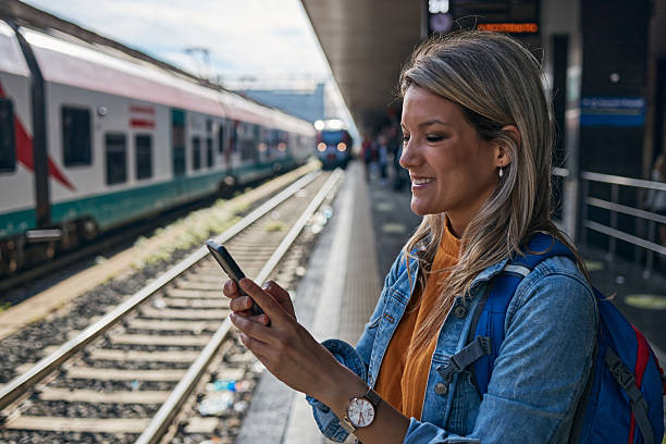 istock Young female tourist using a phone while waiting for a train 2208978541