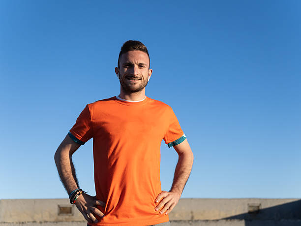 istock Young sportsman listening music while resting after training on breakwater 2208980642