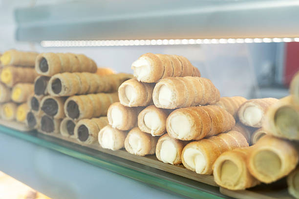 istock Delicious cream rolls displayed on wooden tray in bakery window 2208982547