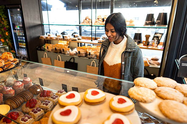 istock Woman Admiring Delicious Desserts In Bakery Display 2208986134