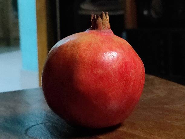 istock Close-Up of Ripe Pomegranate Fruit with Dark Shadows Background 2208988624
