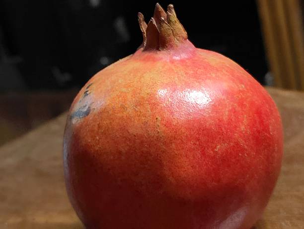 Close-Up of Ripe Pomegranate Fruit with Dark Shadows Background
