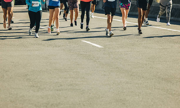 istock Marathon runners on tarmac road during a sunny day 2208988937