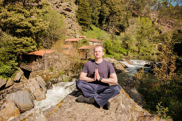 istock Man meditating by the river in the mountains 2208990916