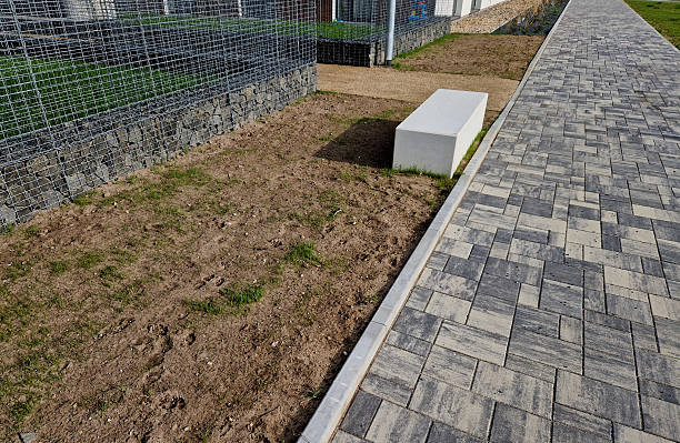 istock Concrete blocks with both sides shaped like cubes are seats in the park. A massive park bench forms a small courtyard with a gravel path surrounded by flower beds. 2208995625