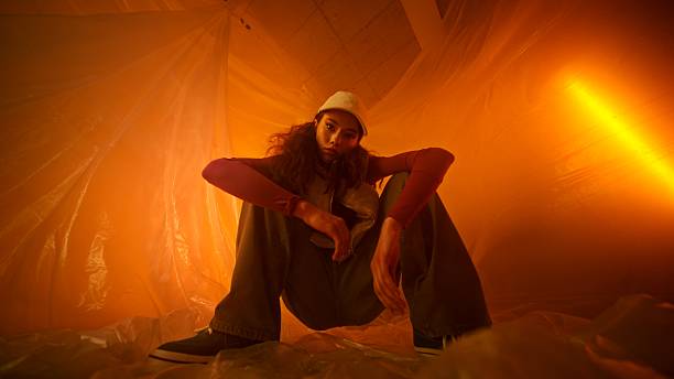 istock A Stylish Artist is Posing Thoughtfully in an OrangeHued Abstract Environment 2208997656