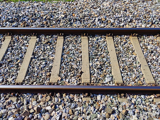 Railway train track with gravel underneath.
