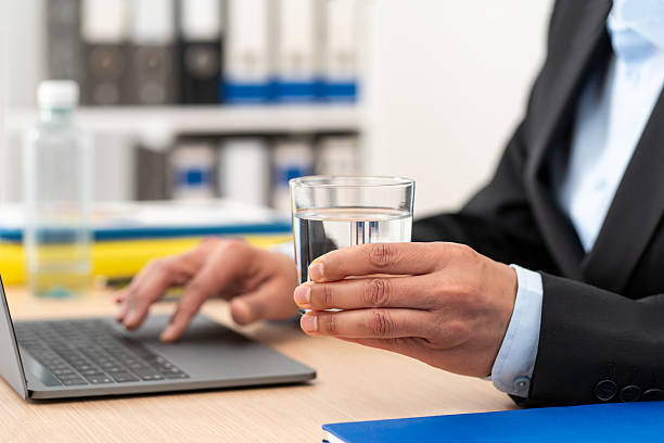 istock Businessman drinking a water glass at the office 2209004574