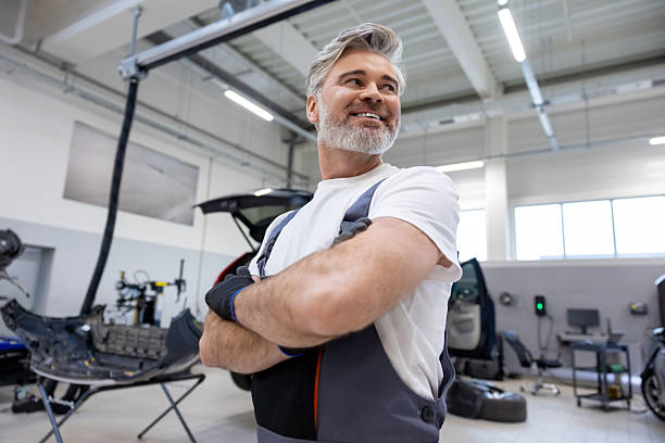 istock Gray haired mechanic in workshop checking and fixing automobile parts 2209009802