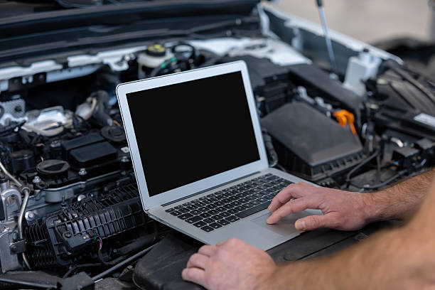 istock Man in auto industry profession checking motor with computer in service 2209009977