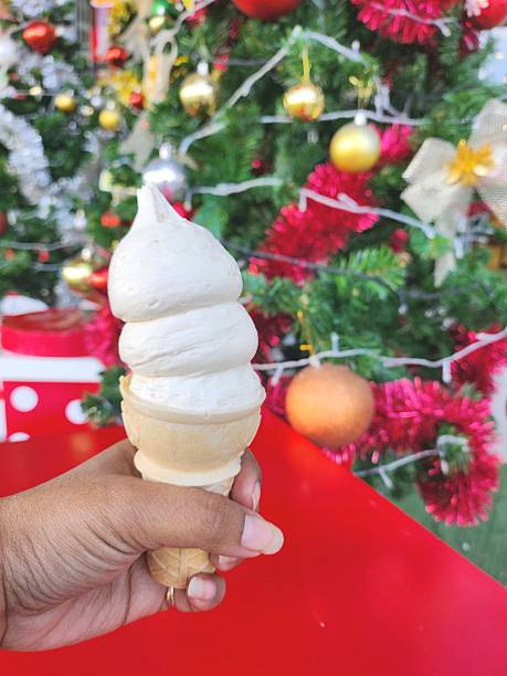 istock Ice cream in crispy cones on hand and christmas decorations 2209010779