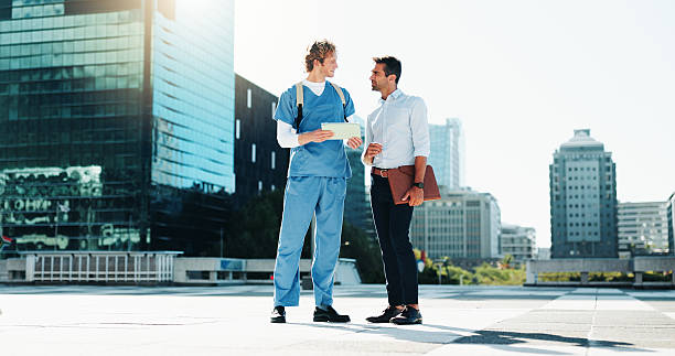 istock Discussion, city and professor with medical student for support, advice or tips for exam. Conversation, meeting and lecturer with healthcare intern for university test review outdoor in urban town. 2209014017