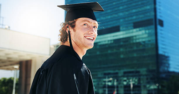 istock Graduation, ideas and student with man outdoor for celebration or education event. Future, scholarship and thinking with happy college or university graduate in urban town for milestone or vision 2209014022