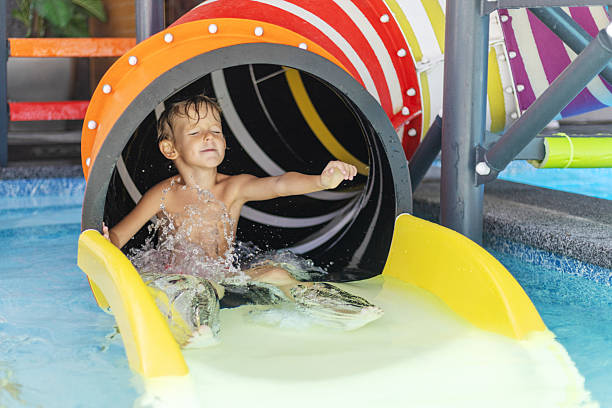 istock Boy sliding down colorful water slide 2209014538