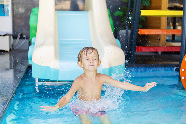 an 8 year old boy is riding in the water Park on inflatable circles on water slides.