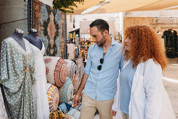 istock Tourists admiring traditional clothes and carpets in Old Dubai's souk 2209014683