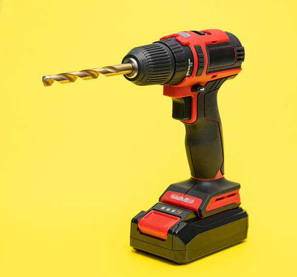 istock Cordless screwdriver with a drill on a yellow background. vertical 2209016223