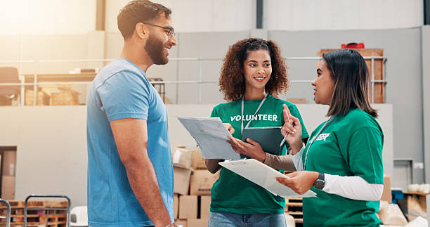 istock Warehouse, volunteers and people with clipboard, smile and review of donations on document or discussion. Social responsibility, tablet and group in factory with food for community service or charity 2209016708