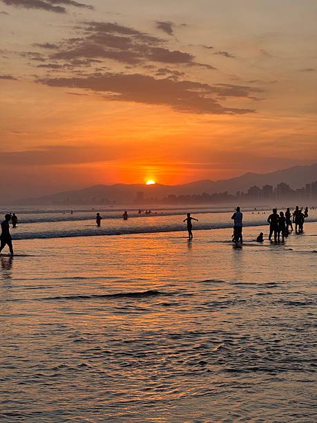 istock Beach sunset with silhouettes and cityscape. 2209016931