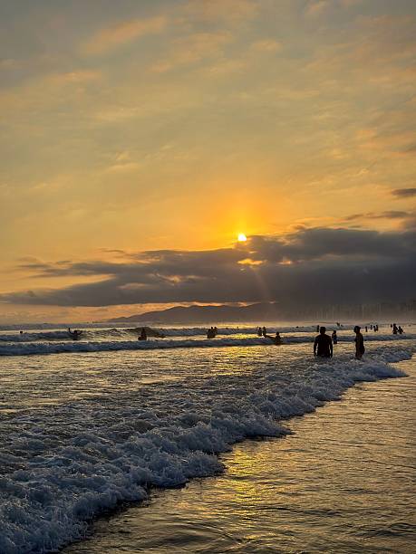 istock Beach sunset with silhouetted figures and golden sky. 2209016947