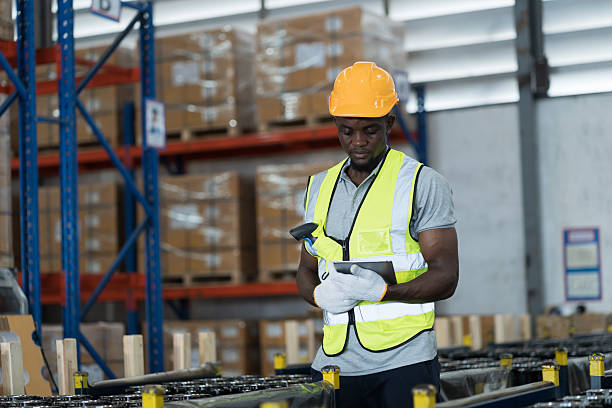 istock Distribution warehouse, Multi-ethnic workers, Product barcode scanner, African American male warehouse worker wear safety uniform, helmet and inspecting quality of products in storage warehouse 2209017575