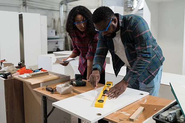 istock Plywood processing plant. Furniture manufacturing. Two worker working together, using carpenter tools in furniture factory. Unity and teamwork concept 2209018214