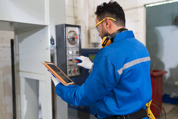 istock Plywood processing plant. Furniture manufacturing. Operator use digital tablet controls CNC cutting machine at industry factory 2209018646