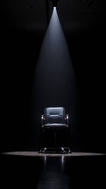 istock Dramatic Spotlight on an Empty Chair in a Dark Room 2209024635