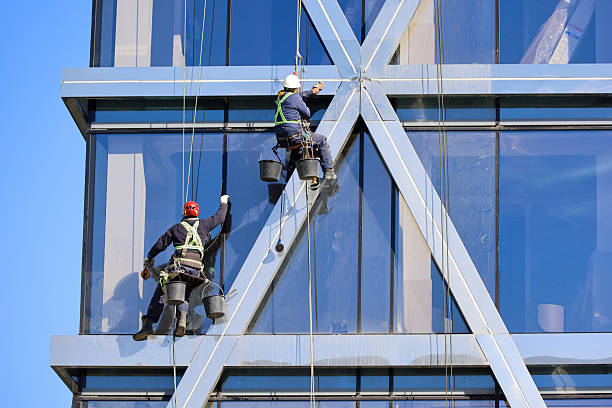 Moscow, Russia - April 4, 2025: Two men washes the building windows on city street in Moscow