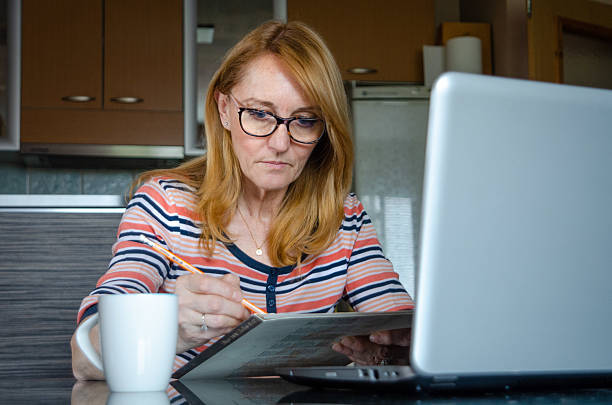 istock Senior woman sketching during an online drawing class. Her focused expression reflects her dedication to honing her artistic skills. 2209025152