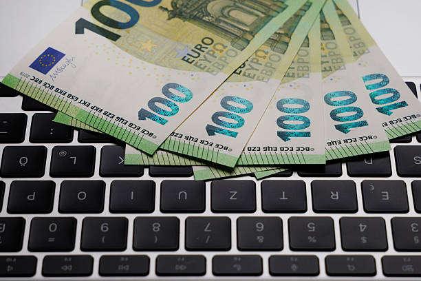 Euro banknotes on computer keyboard – concept for online banking and digital finance
