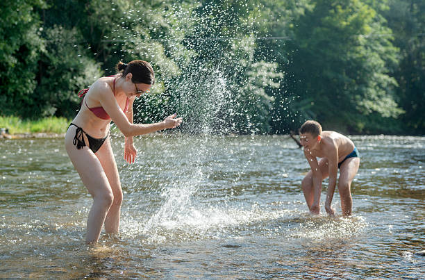 Mother and son play and splash in the river