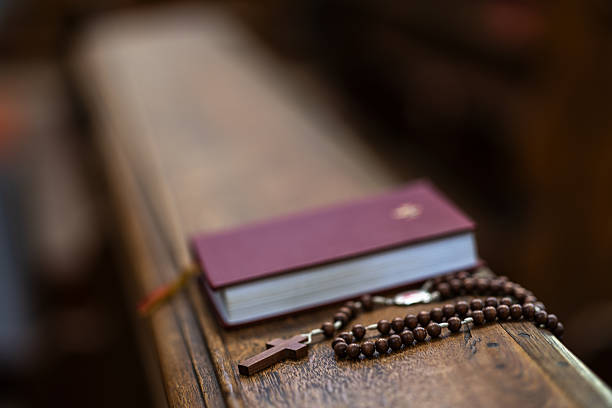 Red Bible on a wooden church pew, illuminated by warm, soft lighting.