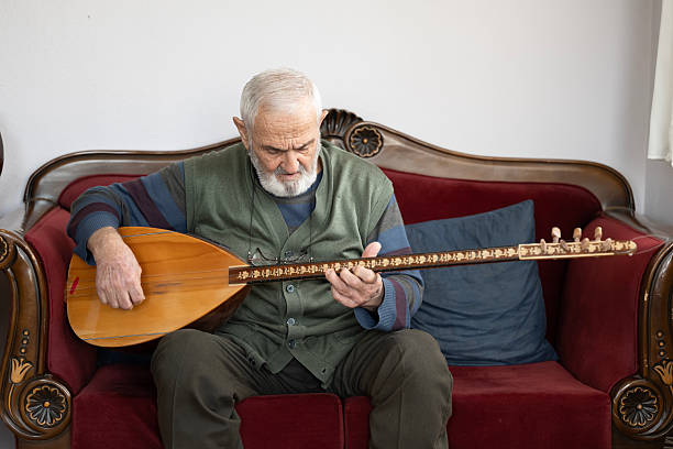 An elderly man performing turkish string instrument baglama