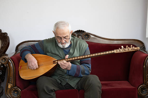 An elderly man performing turkish string instrument baglama
