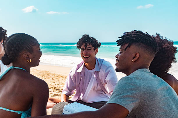 istock Young friends talking on the beach 2209035715
