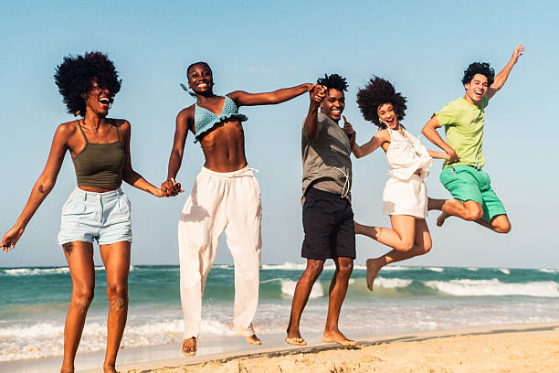 Young friends jumping on the beach