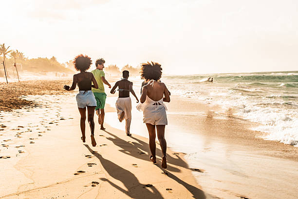 Happy young friends running on the beach