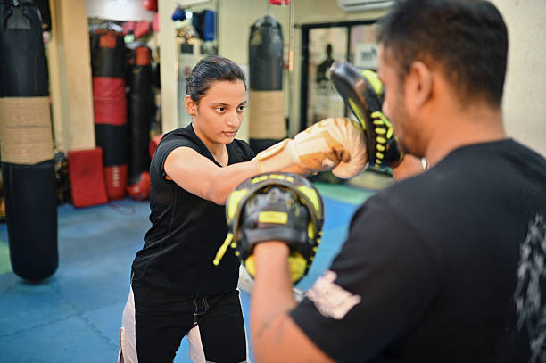 istock Young woman martial arts fighter working out with her trainer 2209036498